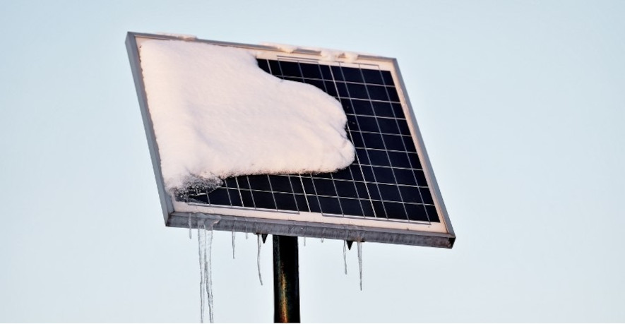 Solcellepanel delvis dekket av snø